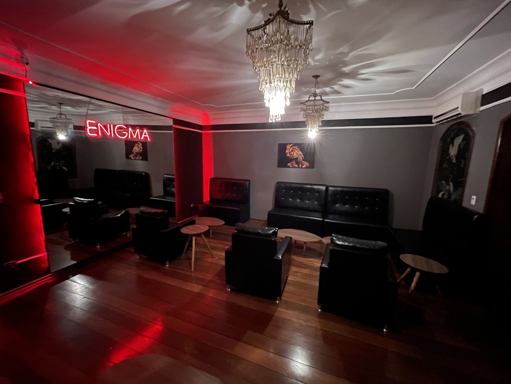 Lounge sofisticado da Enigma com lustres e sofás
